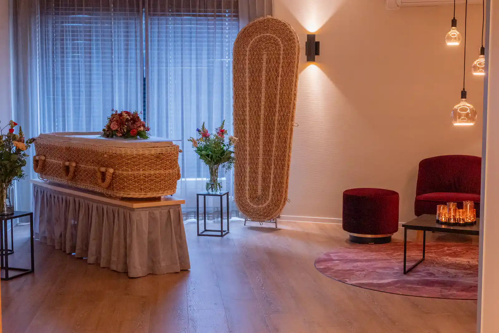 Een gevlochten uitvaartmand met bloemen in een rustige opbaarkamer